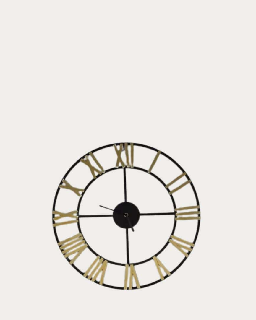 Small black and gold skeleton clock with Roman numerals on a white background.