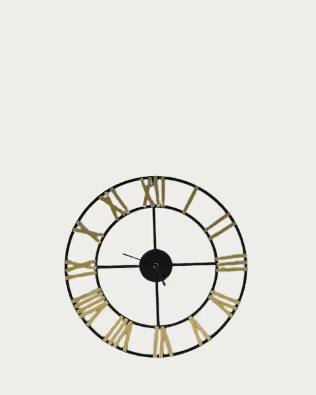 Small black and gold skeleton clock with Roman numerals on a white background.