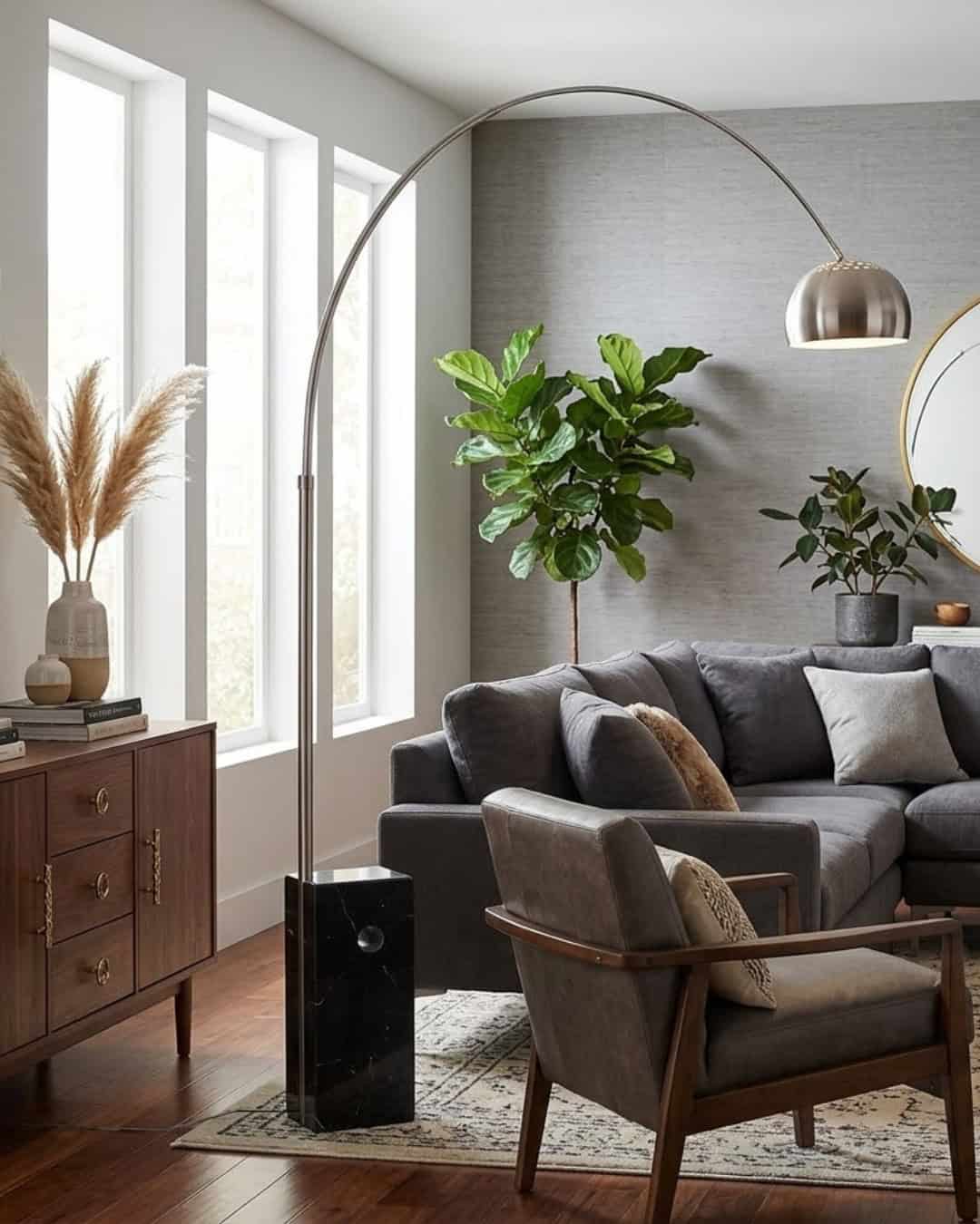 Large black marble-based floor lamp with curved metal arm in modern living room.