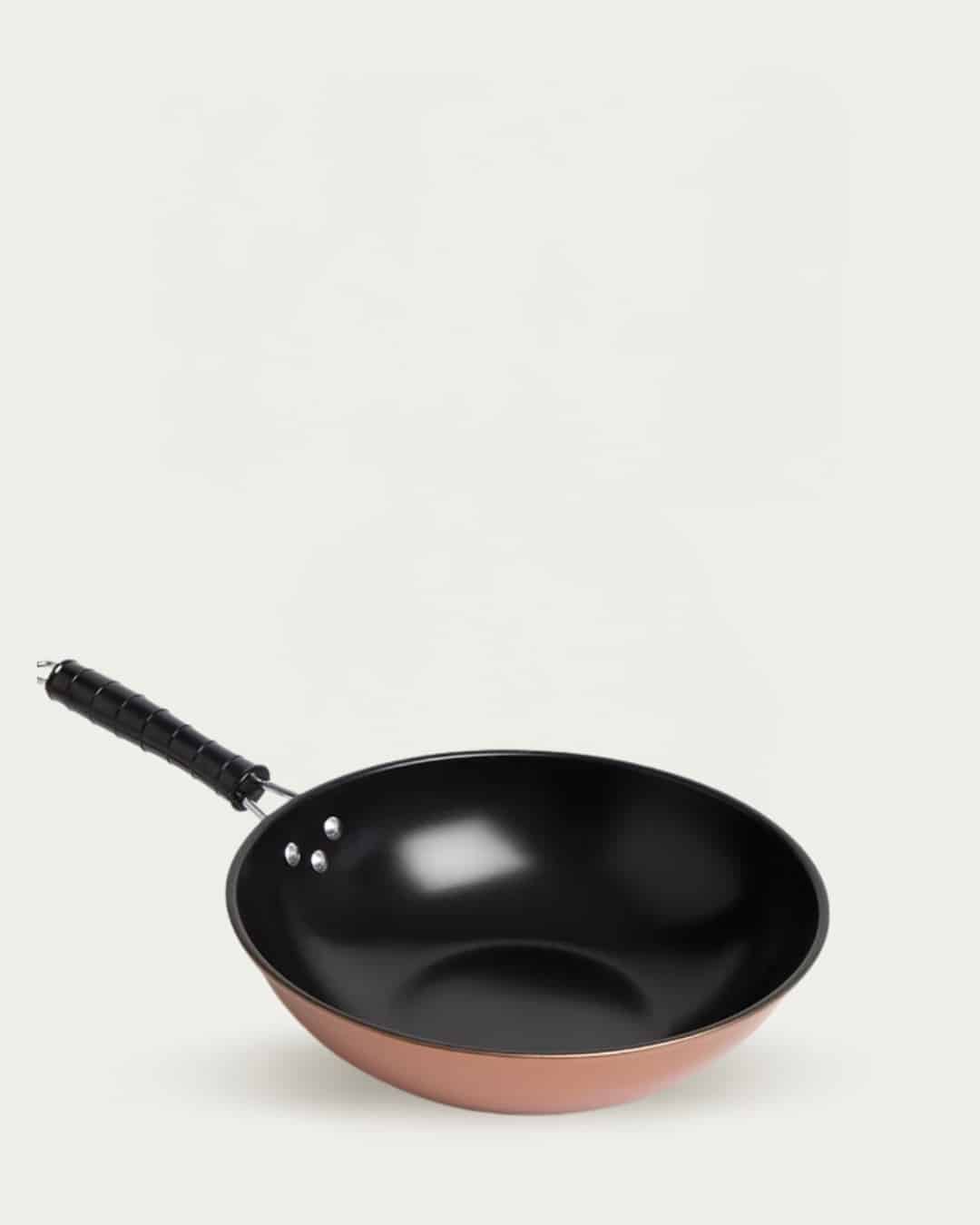 Non-stick black and copper frying pan with ergonomic handle for versatile cooking.
