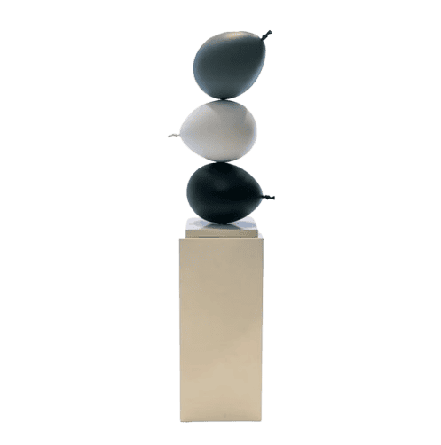 Elegant balancing stones sculpture on a beige pedestal, ideal for contemporary interior accents.