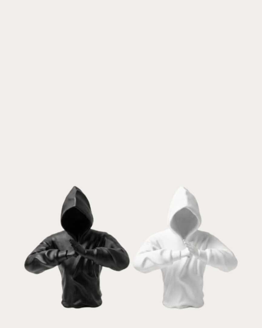 Black and white hooded man with fists raised in a peace or protest gesture.