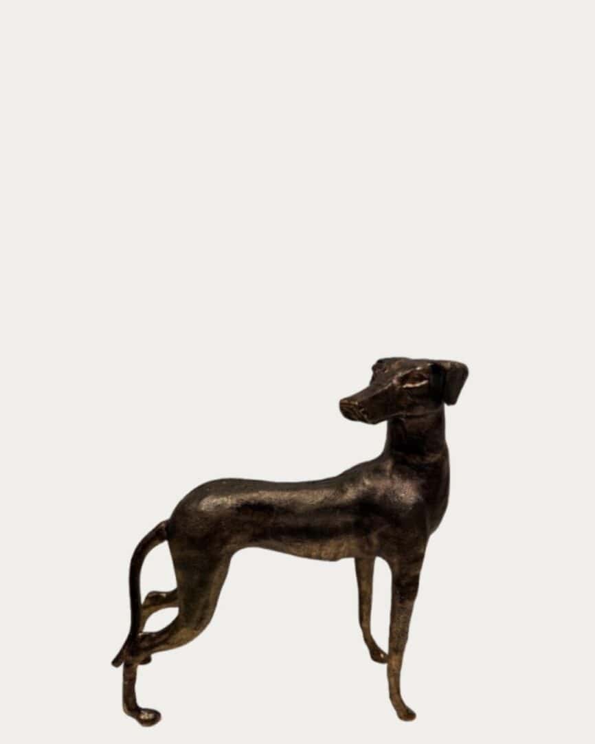 Bronze dog ornament, elegant looking back design, perfect for home decor or garden accents.