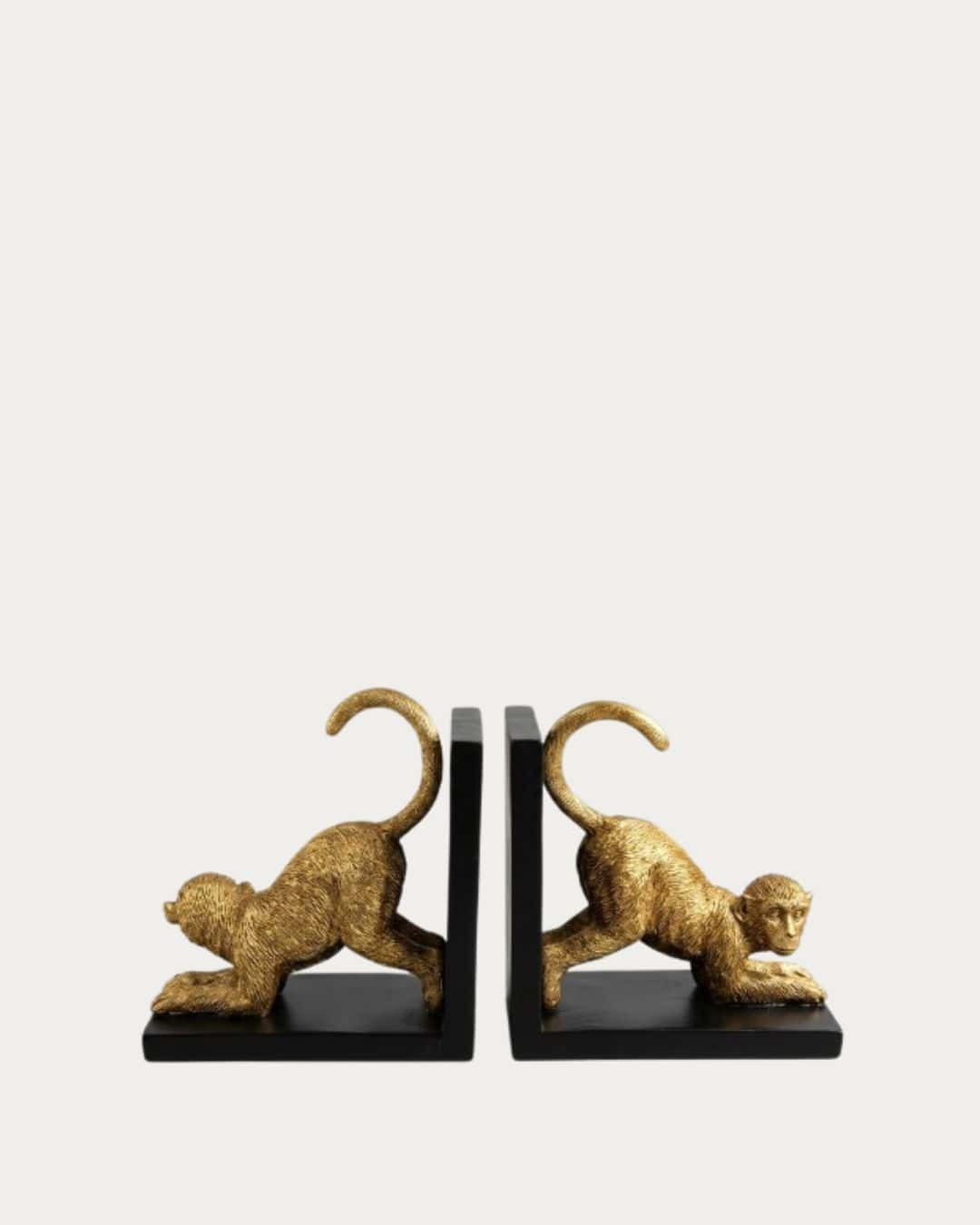 Goldtone monkey bookend set with black bases, decorative and functional home decor accessory.