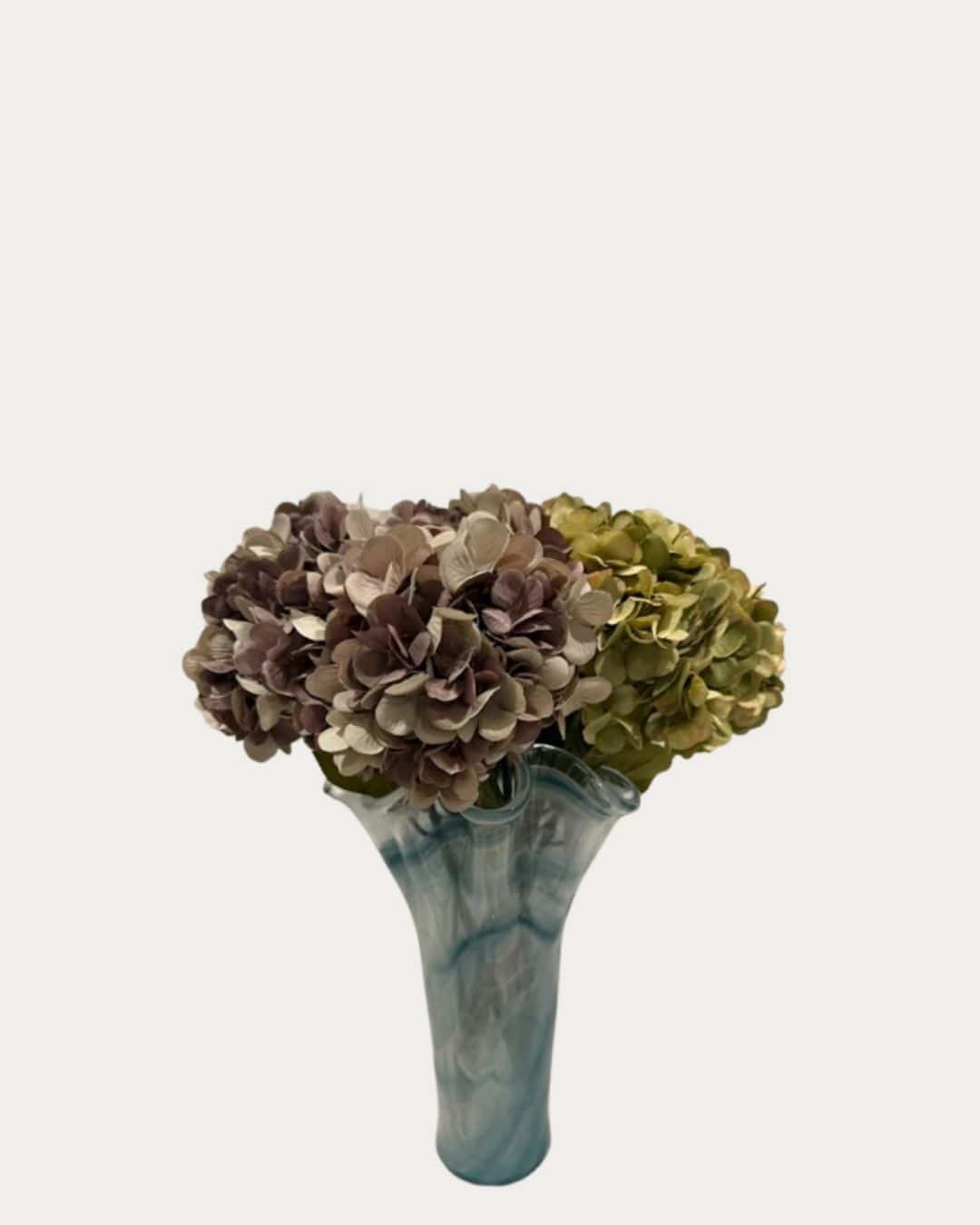 Hydrangea stem flower arrangement in a blue ceramic vase, perfect for home decor.