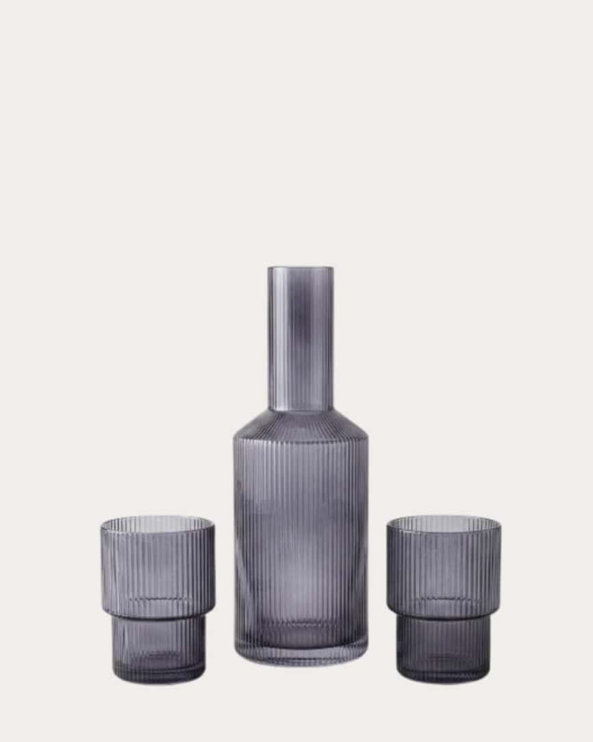 Ribbed glass drinking set with a tall bottle and two matching tumblers for elegant beverage service.
