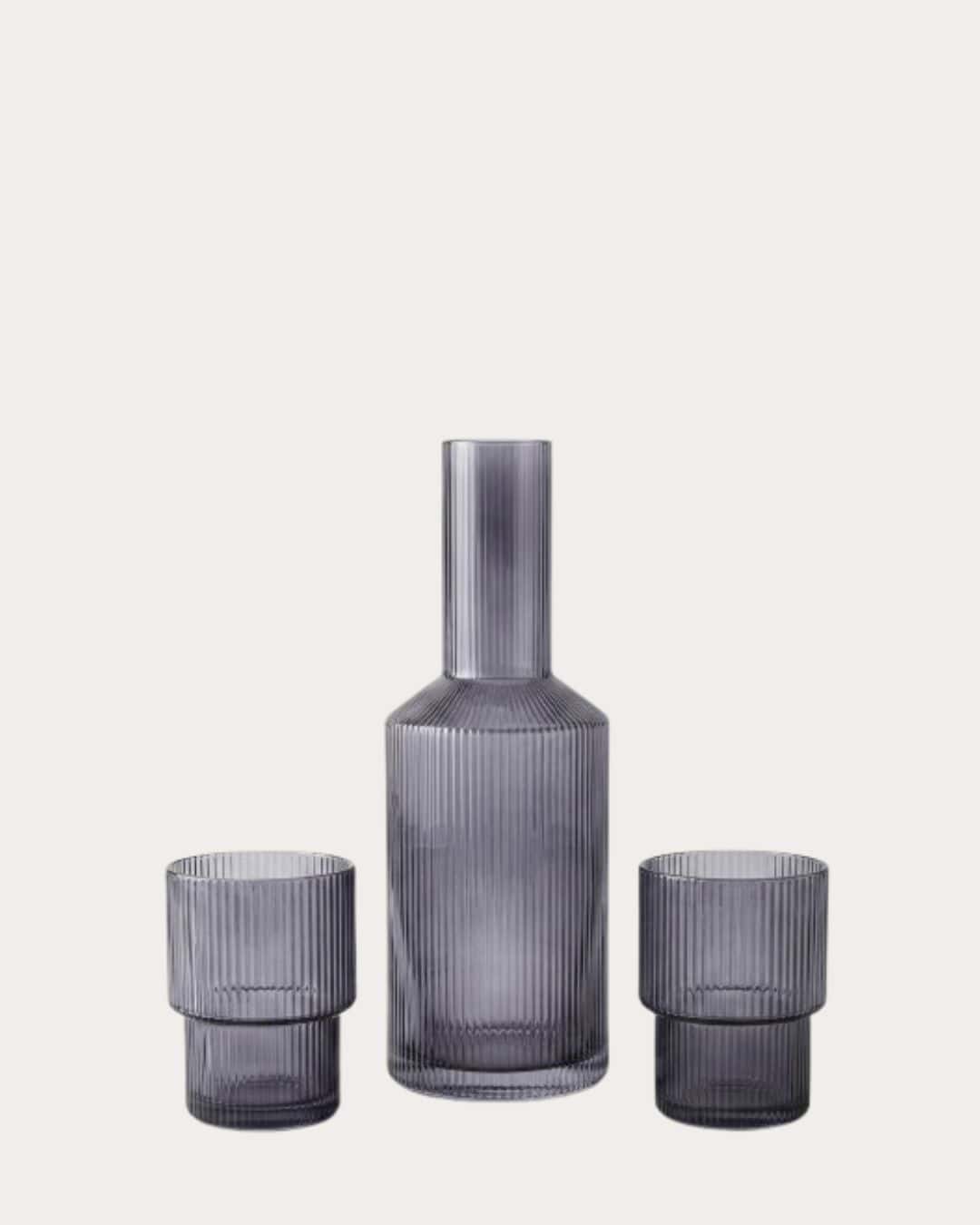 Ribbed glass drinking set with a tall bottle and two matching tumblers for elegant beverage service.