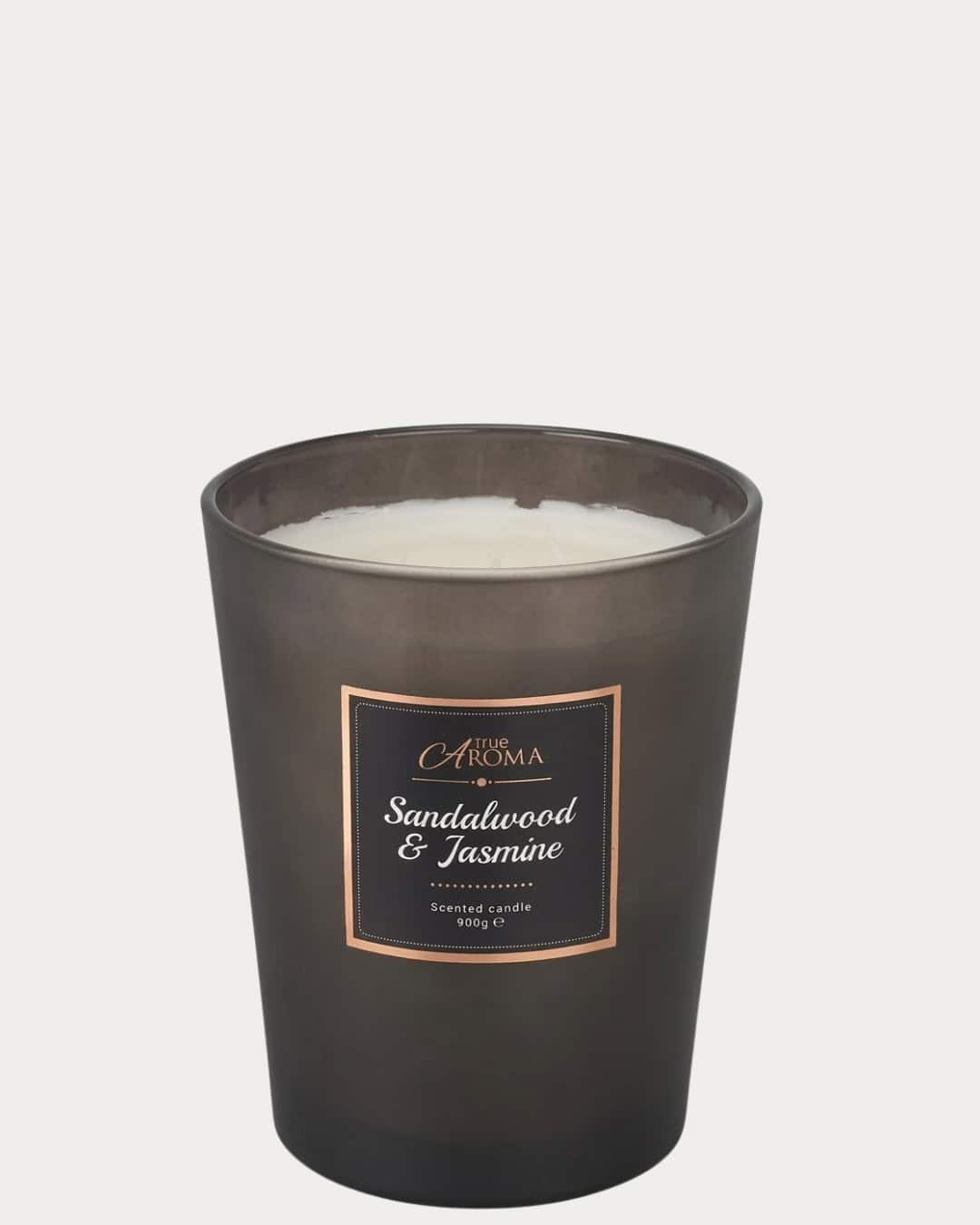 Sandalwood scented candle in a large black jar for a calming aroma and cozy ambiance.